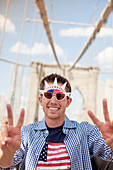 Man in novelty sunglasses on urban bridge