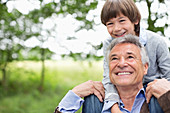 Man carrying grandson on his shoulders