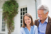 Man and granddaughter smiling outdoors