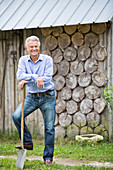 Man standing with shovel outdoors