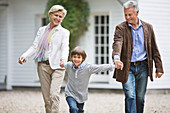 Couple walking with grandson outdoors