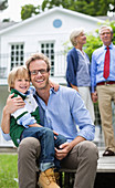 Father and son smiling outside house