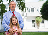 Man and granddaughter smiling outdoors