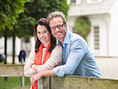 Couple smiling by wooden fence