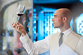 Waiter examining glass of wine
