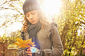 Girl carrying autumn leaf outdoors