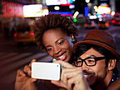 Couple taking pictures on city street