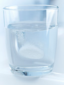 Pill fizzing in glass of water