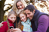 Family using cell phone outdoors