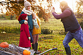 Father taking picture of family outdoors