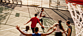 Men playing basketball on court