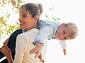 Mother carrying son on shoulders outdoors