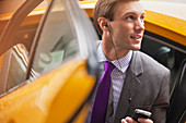 Businessman climbing out of taxi