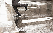 Businessman stepping in puddle
