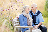 Older couple relaxing on park bench