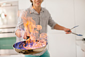 Man cooking with fire in kitchen
