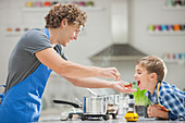 Father and son cooking in kitchen