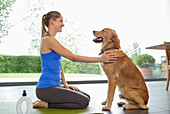 Woman practicing yoga with dog