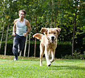 Man running with dog in park