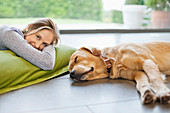 Smiling woman relaxing with dog on floor