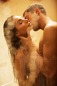 Nude couple kissing in shower