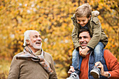 Three generations of men smiling in park