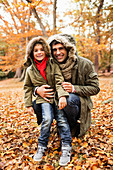 Father and son standing in autumn leaves