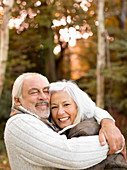 Older couple hugging in park