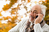 Older man talking on cell phone in park