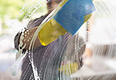 Man washing window with sponge
