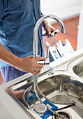 Plumber working on kitchen sink