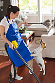 Maid playing with dog in living room
