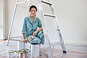 Smiling woman painting room