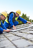 Workers installing solar panels on roof