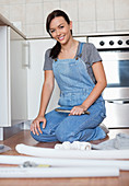 Woman working on pipes in kitchen