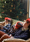 Children in paper crowns sleeping on sofa