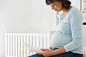 Pregnant woman reading in nursery