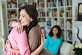 Women hugging in living room