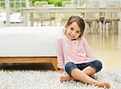 Smiling girl sitting on rug