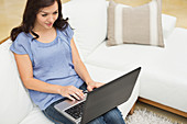 Woman using laptop on sofa