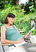 Pregnant woman using tablet computer