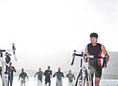 Triathletes emerging from water,
