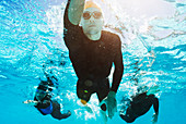 Triathletes in wetsuits underwater