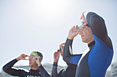 Triathletes adjusting goggles outdoors
