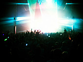 Fans facing illuminated stage