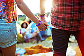 Couple holding hands outside tents