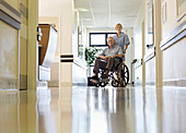Nurse wheeling older patient in hospital