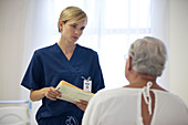 Nurse and older patient talking room