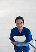 Nurse holding folders in hospital hallway