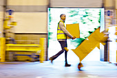 Blurred view of workers carrying boxes